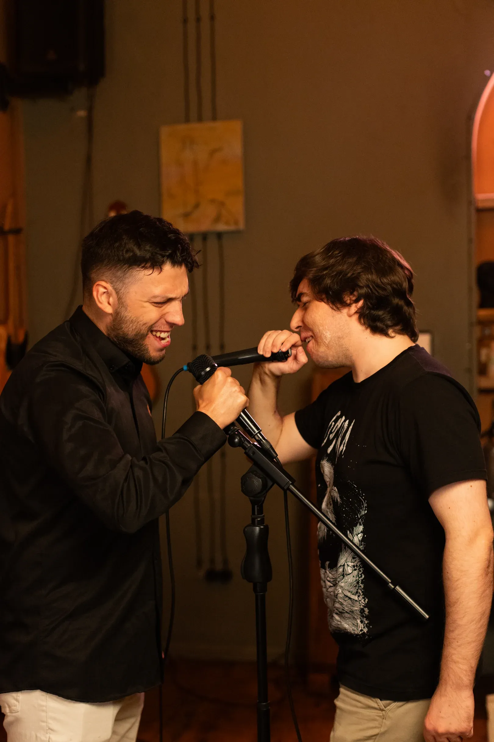 The two karaoke hosts sharing one microphone mid-song