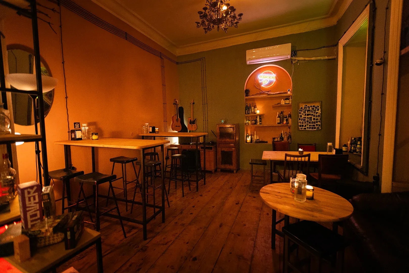 The second room set up with high tables and stools under warm light